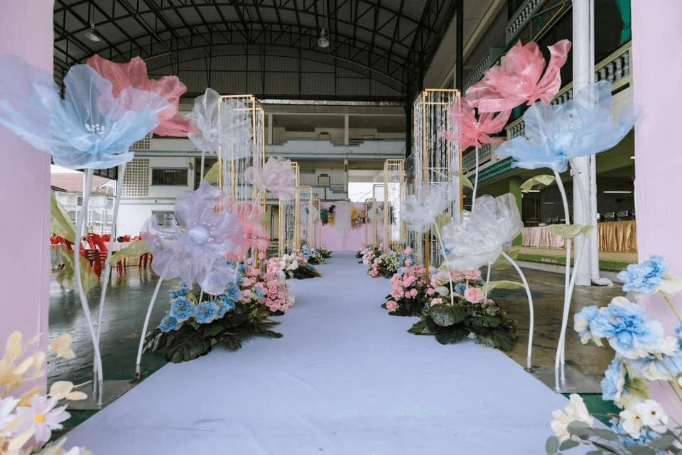 Oversized tulle flower installation lining an aisle in blush and sky blue