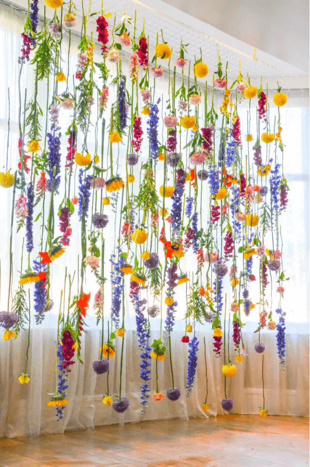 Colourful flowers hanging on long stems in rows, in yellow, purple, pink and red