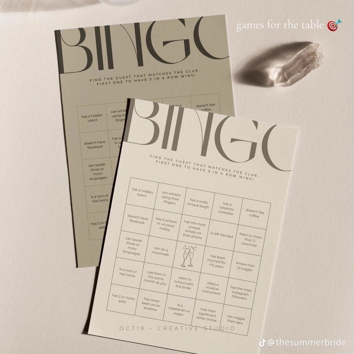 Two bingo cards with a 5 by 5 grid of clues, such as has a hidden talent and can speak three or more languages, with champagne glasses in the middle square