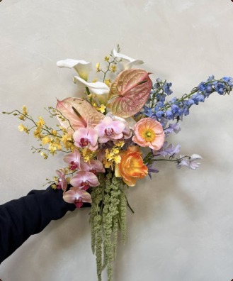 Hand-held bouquet with orchids, anthurium, delphinium and trailing amaranthus