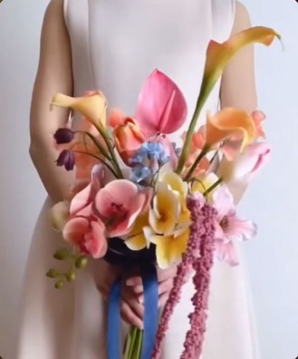 Bridal bouquet of calla lilies and orchids tied with blue ribbon