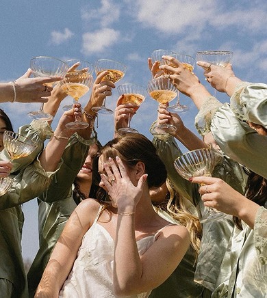 Coupe glasses raised against a blue sky