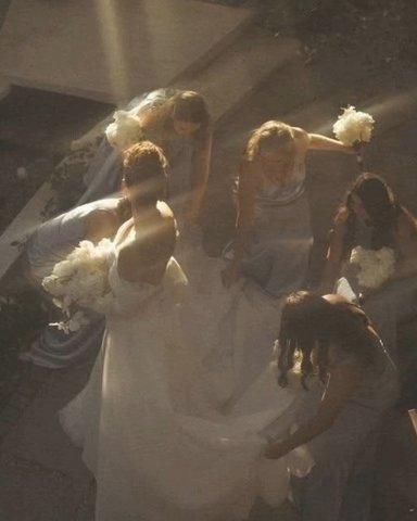 Bridesmaids fluffing the dress in the sunlight