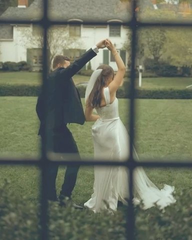 Couple dancing on the lawn, seen through a window