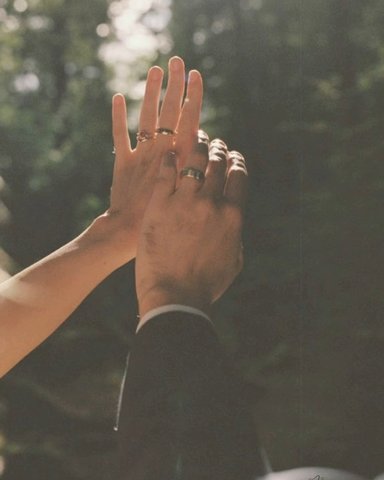 Raised hands showing both wedding rings