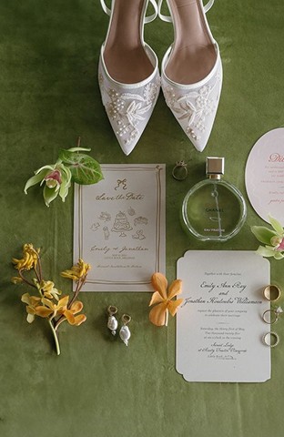 Invitation suite, shoes, perfume and orchids on green velvet