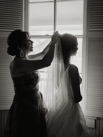 Black-and-white silhouette of the veil being placed