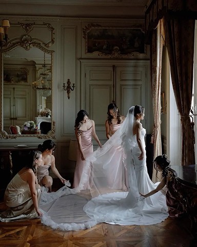 Bridesmaids adjusting the dress and veil in an elegant room